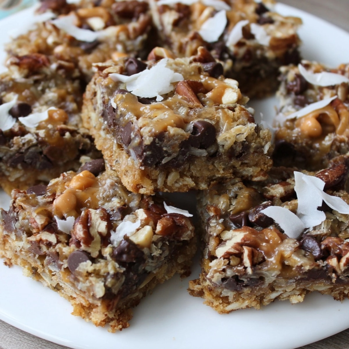 Golden Seven-Layer Bars showcase melted chocolate, toasted nuts, coconut flakes, and buttery crust.