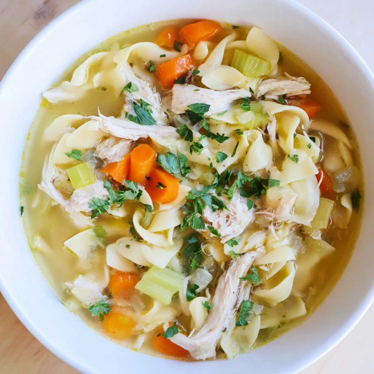 Warm, inviting bowl of homemade chicken noodle soup, perfect for a cozy, comforting meal on a cold day.