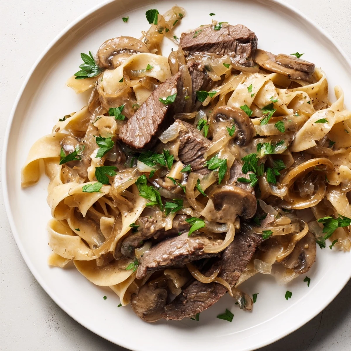 Creamy Mushroom Beef Stroganoff: steaming hot, savory beef stroganoff with tender beef and mushrooms on a bed of noodles.