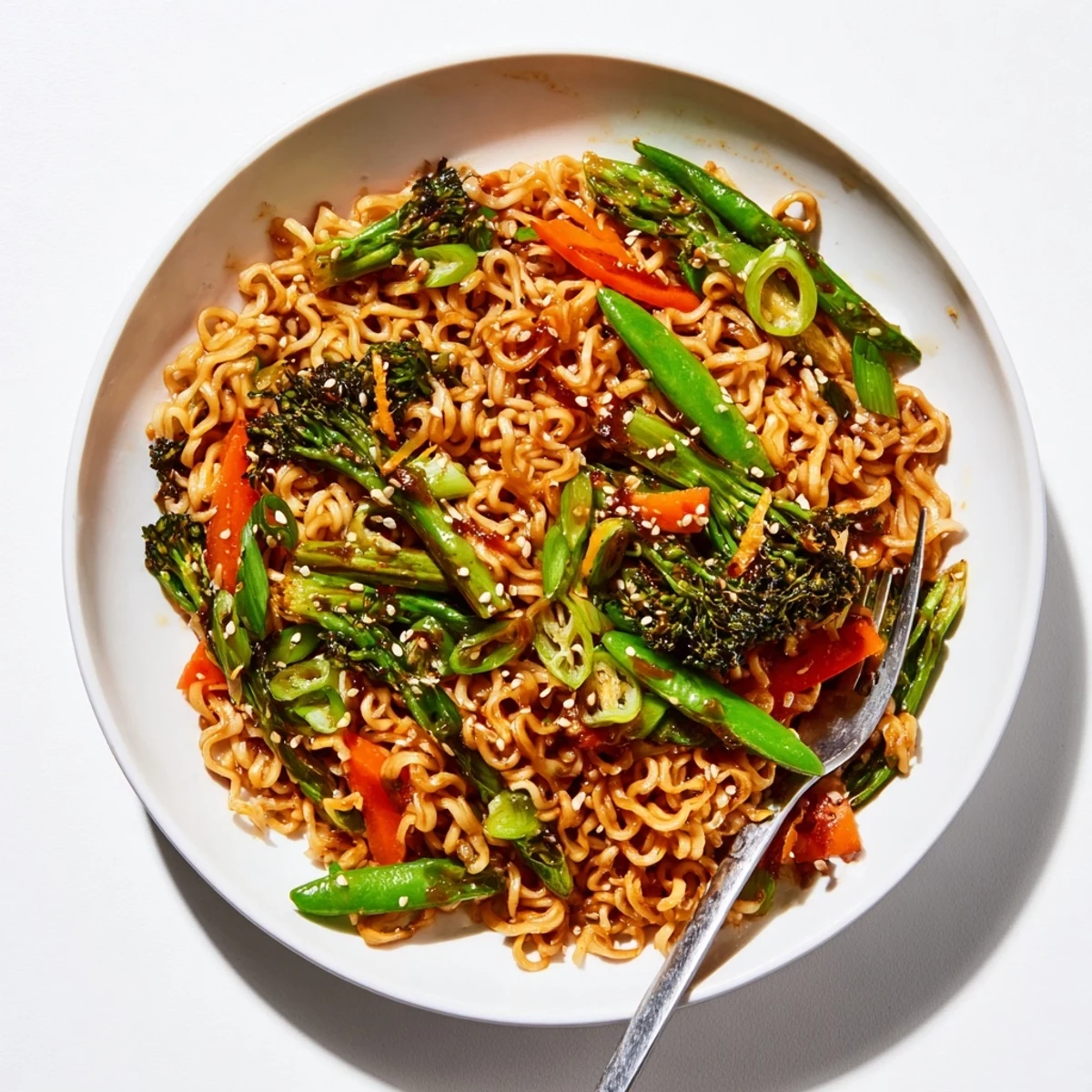 Steaming hot Ramen Noodle Stir-Fry Remix with vibrant vegetables and sesame seeds, ready to savor.
