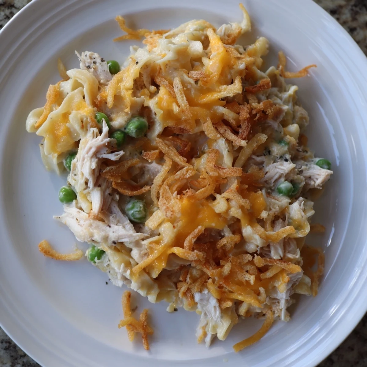Golden-brown Homemade Tuna Noodle Casserole with a crispy onion topping ready to serve.
