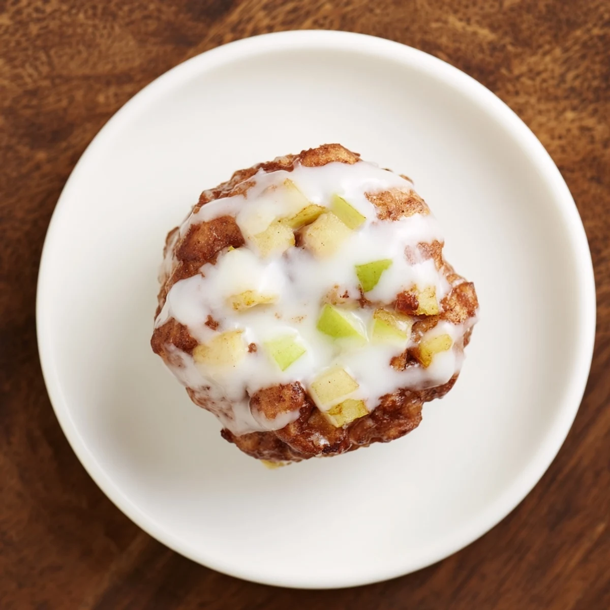 Freshly fried apple fritters, aromatic with cinnamon and nutmeg, served warm with a sweet glaze drizzle.
