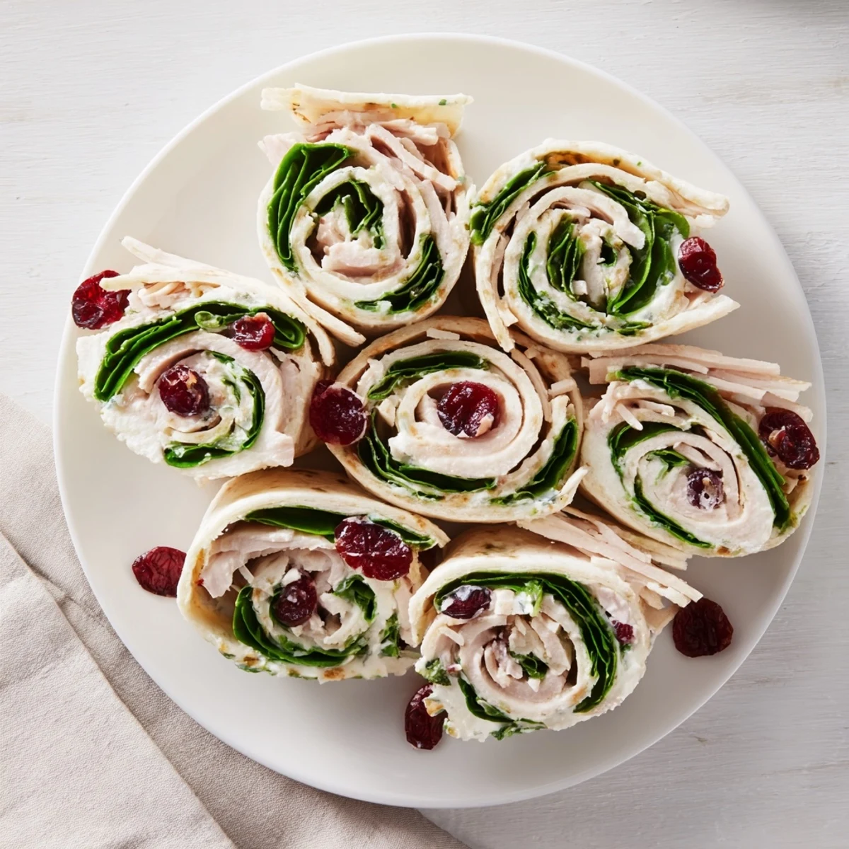 Sliced Turkey Cranberry Pinwheels showing layers of turkey, cream cheese, and cranberries for a quick appetizer.