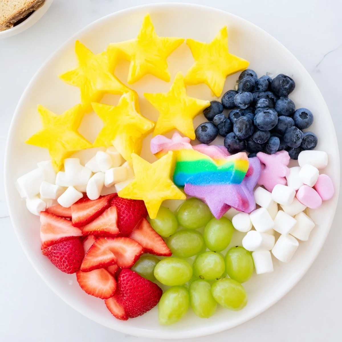 Colorful Unicorn Party Platter, overflowing with fresh fruit, veggies, and whimsical candies for a magical treat.