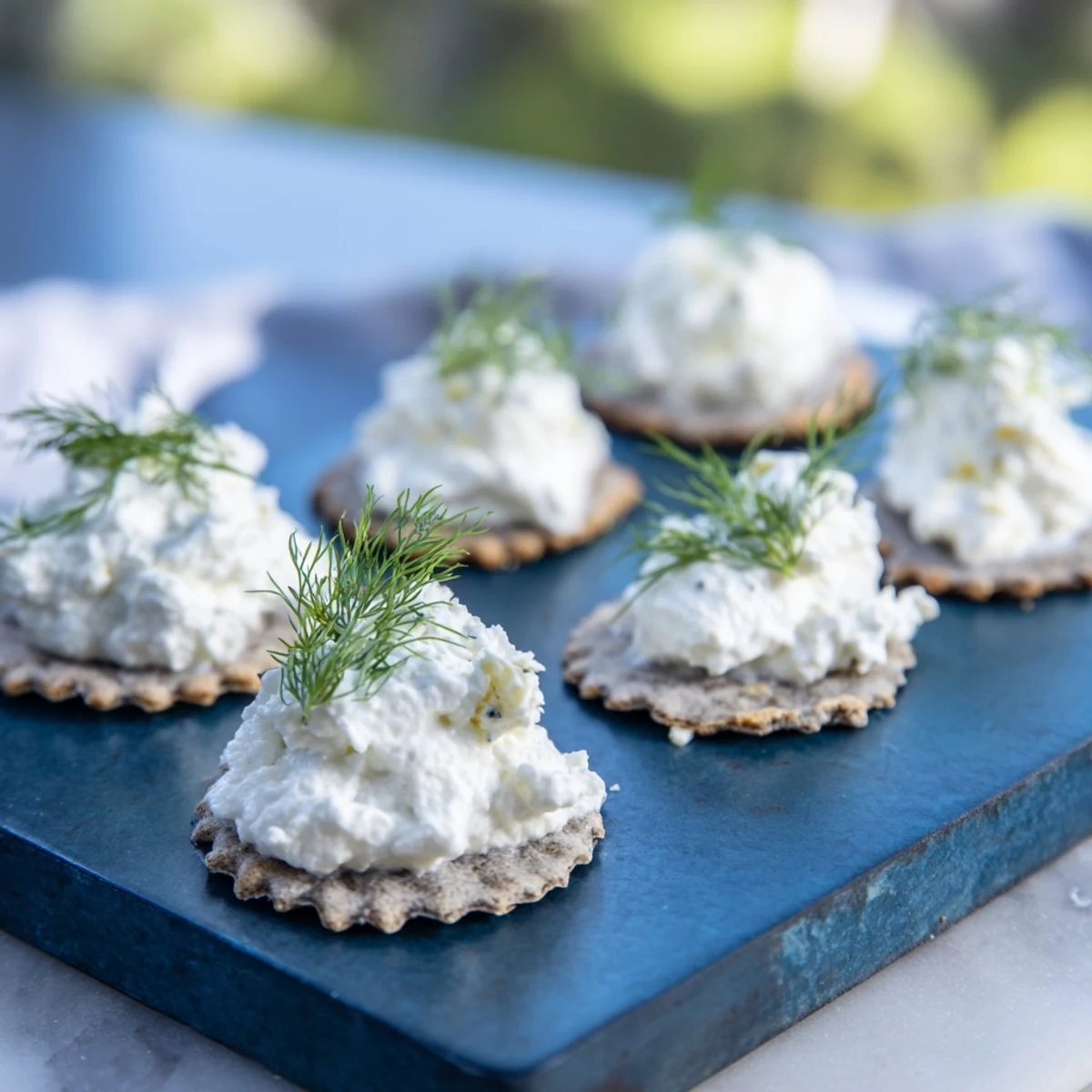 A plate of The Stormy Sea, a captivating appetizer with wavy crackers and fluffy white goat cheese.