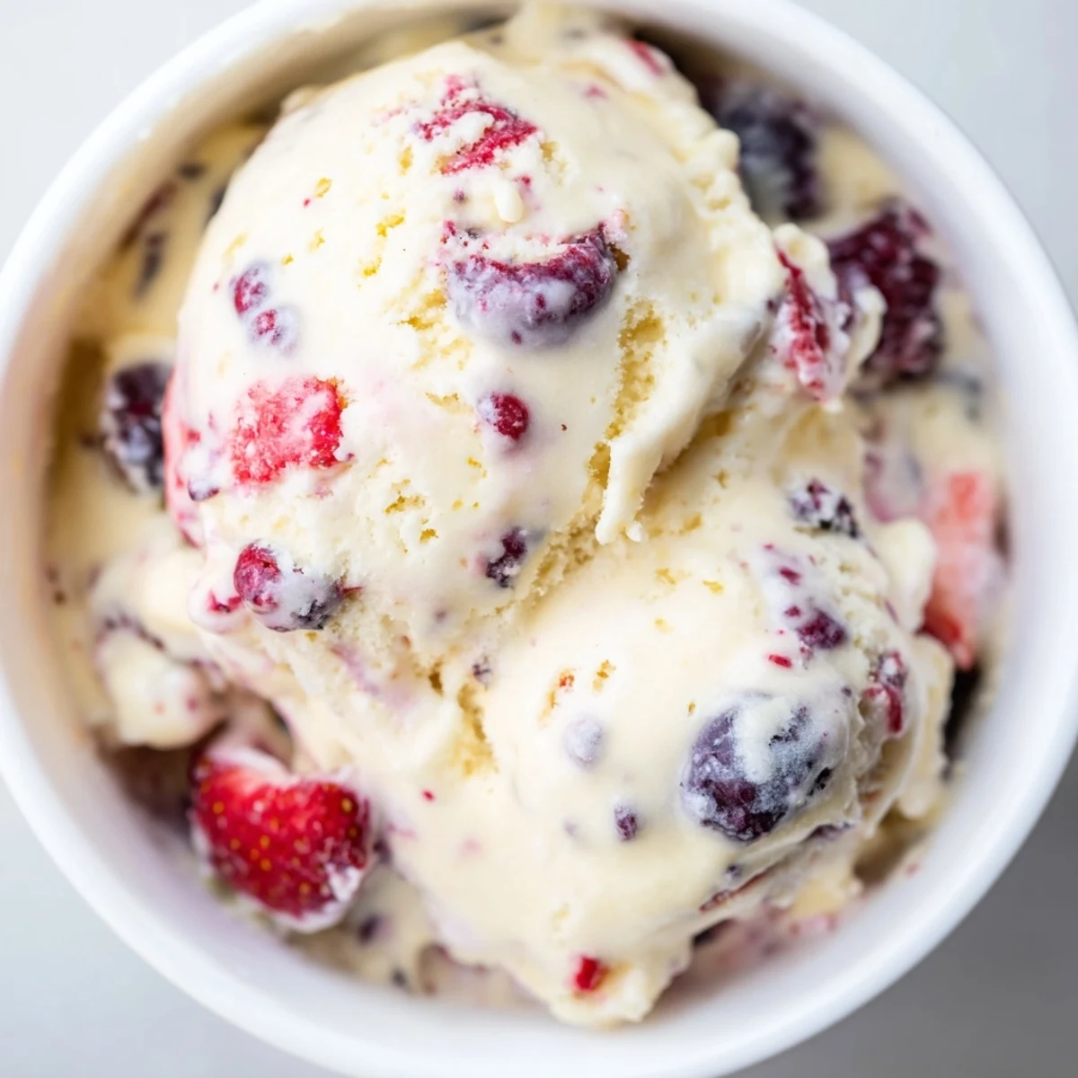 Creamy cottage cheese ice cream, swirled with purple berries, looks refreshing and ready to scoop.
