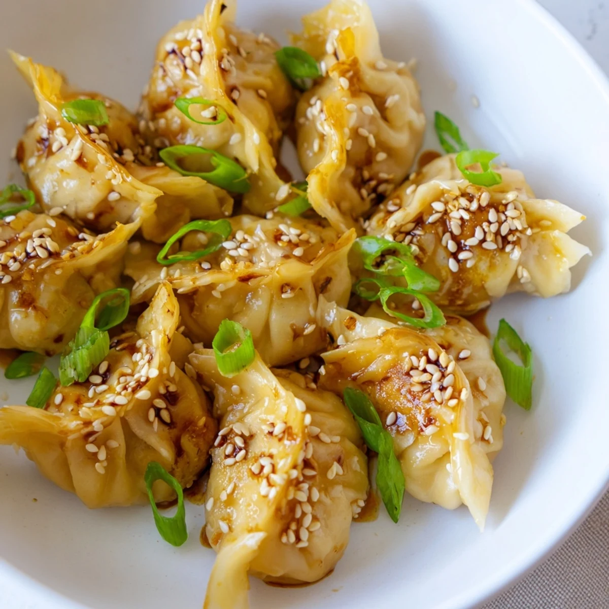 Enjoy a plate of perfectly cooked air fryer frozen dumplings with a flavorful sesame oil coating.