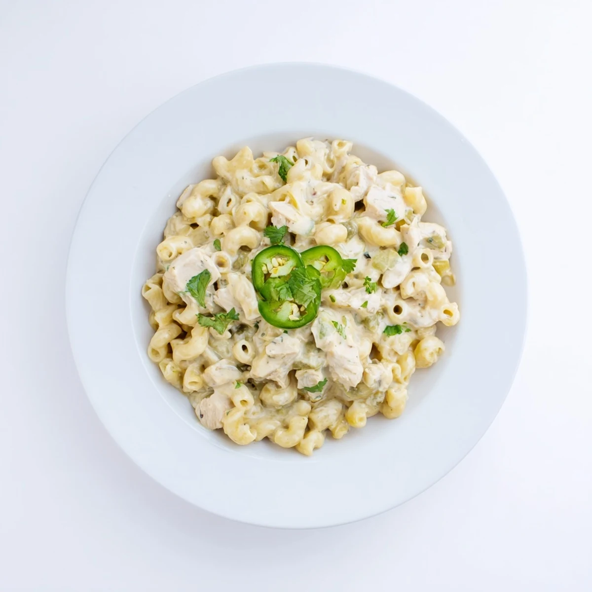 Green Chili Chicken Mac is served hot from the pan, garnished with fresh cilantro and optional spicy jalapeño slices for color.