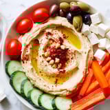 Shareable Middle Eastern Mezze Platter: vibrant hummus, vegetables, cheese, and warm pita bread ready to enjoy.