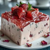 Elegant ring cake with layers of strawberry and rose gelatin suspended in silky cream, offering a fragrant, refreshing taste with every slice.