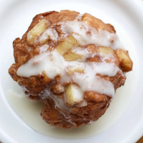 Golden-brown homemade apple fritters, fried to a crisp perfection, ready to eat with a glazed finish.