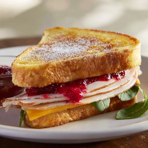 Warm, golden Easy Holiday Waffle Sandwich layered with turkey, cheese, and cranberry sauce, ready to eat.