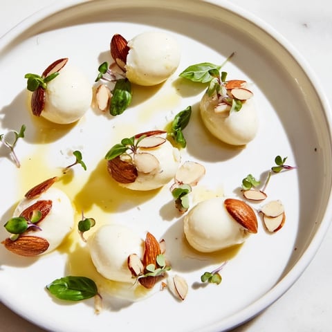 The Polished Pebble: A beautifully arranged appetizer with oval cheeses and roasted almonds, ready to serve.