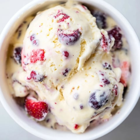 Creamy cottage cheese ice cream, swirled with purple berries, looks refreshing and ready to scoop.
