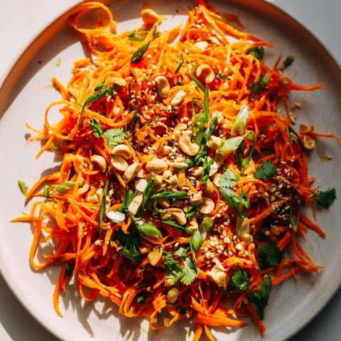 Vibrant Spicy Carrot Salad with shredded carrots and a tangy, spicy glaze, ready to serve.