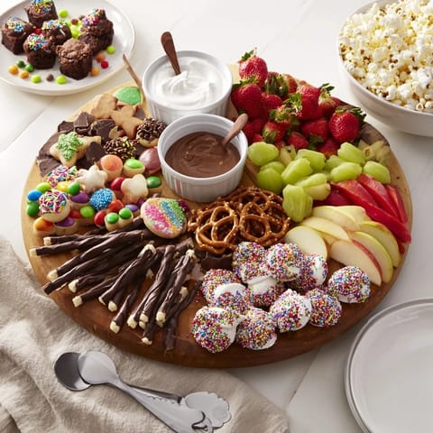 Indulge in a festive dessert board loaded with cookies, fruits, and chocolates.  