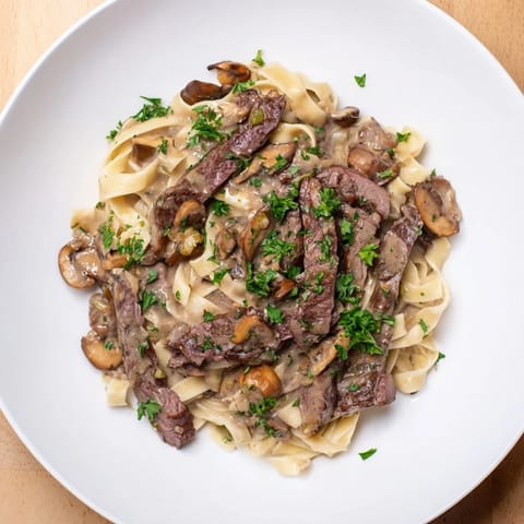This decadent Creamy Mushroom Beef Stroganoff features juicy beef strips and a rich, creamy sauce ready to be devoured.