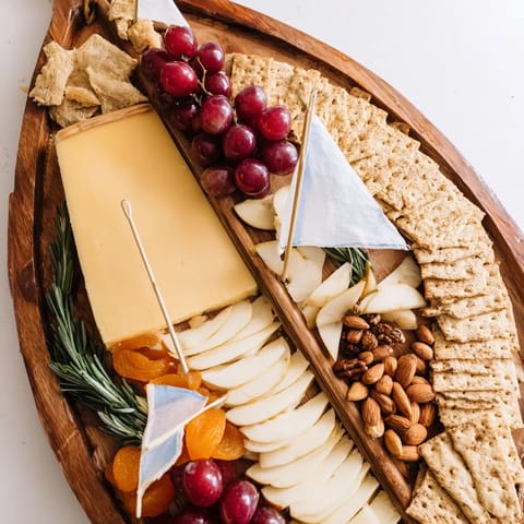 Sailboat Cheese Platter with colorful fruits, nuts, and crackers arranged beautifully for an appetizer.