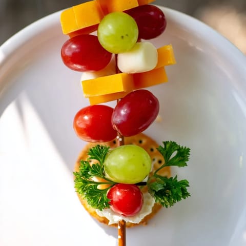 Eye-catching Up, Up, & Away Hot Air Balloon Snacks display vibrant fruits and cheeses on pretzel sticks.
