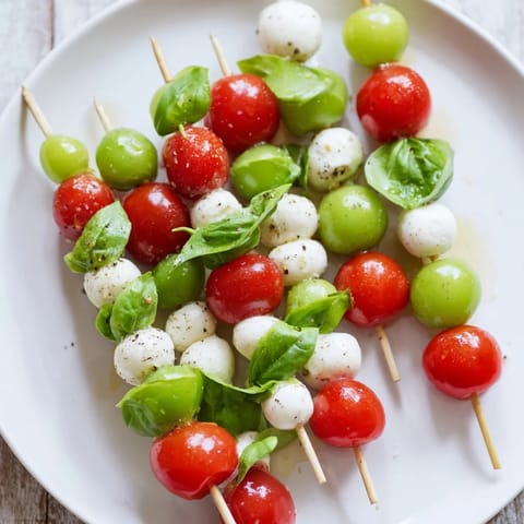 Festive Caprese Skewer Tree appetizer, featuring colorful cherry tomatoes and fresh mozzarella drizzled in olive oil.