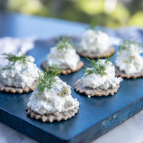 A plate of The Stormy Sea, a captivating appetizer with wavy crackers and fluffy white goat cheese.
