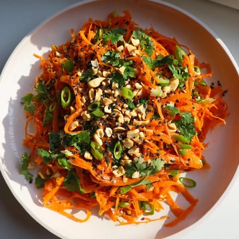 A close-up of a refreshing Spicy Carrot Salad with peanuts, perfect as a side dish.