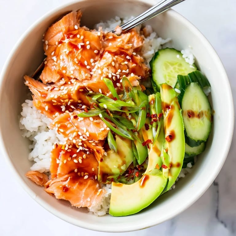 Quick and vibrant leftover salmon & rice bowl drizzled with soy sauce and sesame oil.