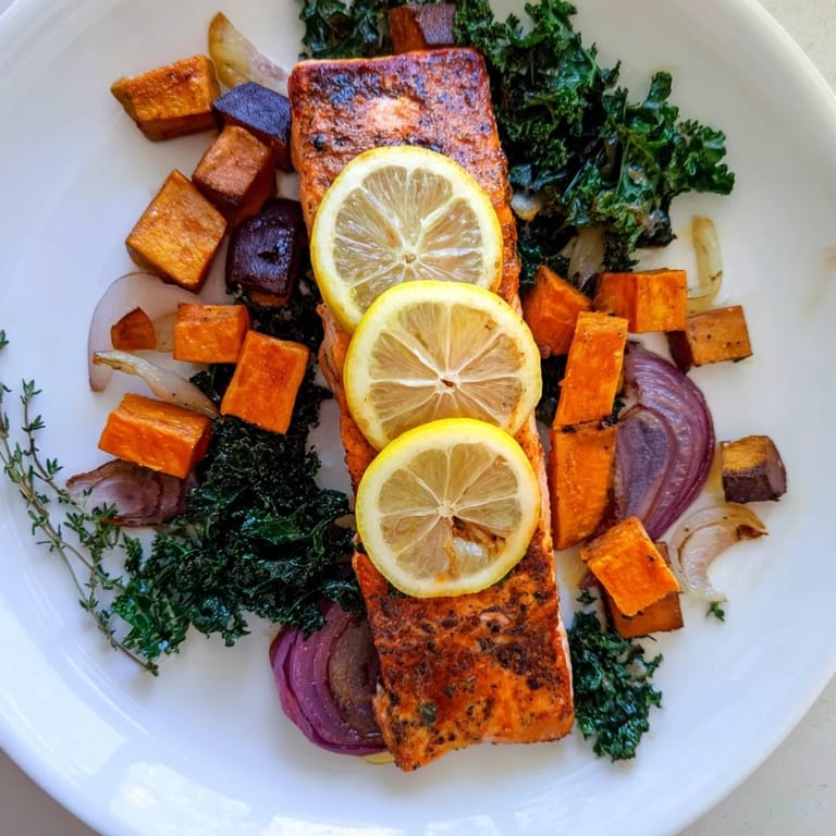Vibrant image of easy Sheet-Pan Salmon, ready to serve with beautifully caramelized vegetables and greens.