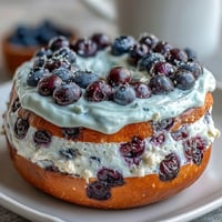 Delicious blueberry protein bagels topped with creamy Greek yogurt frosting, perfect for a healthy and satisfying breakfast. Soft, chewy bagels bursting with juicy blueberries and high-protein goodness, finished with a tangy Greek yogurt glaze. Wholesome homemade blueberry protein bagels with Greek yogurt frosting, ideal for a nutritious and energizing morning meal.